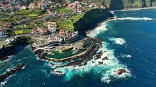 Drone Orbit Around Natural Pools And Town Of Porto Moniz, Madeira Portugal Coastline On Sunny Day