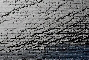 Canvas Print -  a black and white photo of a brick wall with a street sign in the foreground and a blue sky in the background.