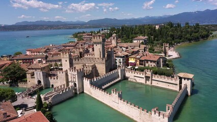 Wall Mural - The historical part of the city of Sirmione on Lake Garda in Italy, slow motion shot by drone. Sirmione drone view circular flight. Scaliger Castle of the city of Sirmione 4K video on drone.