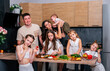 © dvulikaia - Large family - mom, dad, four daughters and baby son together prepare salad for lunch in modern kitchen. Big family together concept.