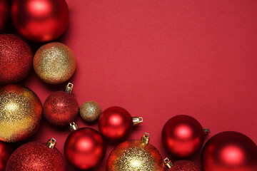 Wall Mural - Christmas balls on red background, top view. Space for text