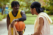 © DragonImages - Black sportsmen discussing game of streetball, active lifestyle concept