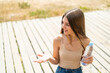 Teenager girl with a bottle of water at outdoors with surprise facial expression