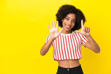 Wall Mural - Young African American woman isolated on yellow background counting seven with fingers