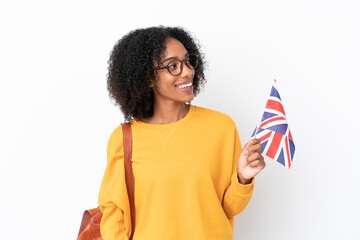 Sticker - Young African American woman holding an United Kingdom flag isolated on white background looking to the side and smiling