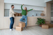© DimaBerlin - Happy joyful couple standing in spacious flat, house, proud of buying, relocation to new apartment. Glad wife showing large space. Cheerful husband smiles delighted with moving into own property