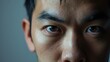 © WS Studio 1985 - Portrait and half eyes of a man isolated on a grey background in studio. Serious, Asian and closeup face of a person with space for expression