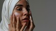 © WS Studio 1985 - Portrait of a glowing beautiful muslim woman isolated against grey studio background. Young woman wearing a hijab
