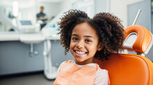 A Smiling African American Kid Sitting In A Dental Chair At The Dentist, Teeth Cleaning And Examination Concept, Beautiful White Teeth Smile, Young Girl Checkup