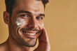 Portrait of handsome man with skincare product on his face