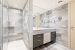 Bathroom with wall separating washbasin with vanity unit from shower