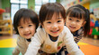© dont - 日本の幼稚園児・保育園児3人が長袖の私服でカメラに向かってきて笑っている写真、背景教室、保育室