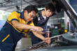 © DG PhotoStock - Senior professional repairman inspecting an oil engine in an old car.