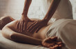 Hands of female chiropractor massaging back of young woman lying on massage table on white background. Visceral massage. Concept of physical therapy treatment, neck pressure point