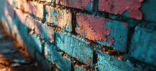 A Brick Wall With Blue And Pink Paint, Showing Signs Of Wear And Tear