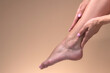 © vladimirfloyd - Closeup woman applying cream and lotion onto foot , beauty girl moisturizer and treatment cosmetic onto toes and heel, skincare cosmetic and healthy concept. Beige background