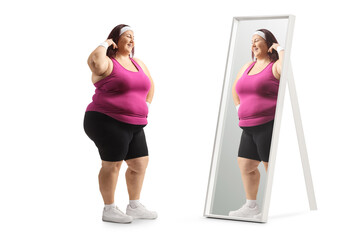 Sticker - Plus size woman in sportswear standing in front of a mirror and thinking