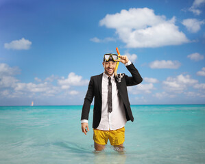 Wall Mural - Businessman standing in the sea in swimming shorts