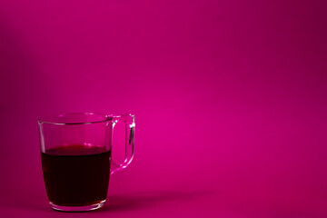 glass of fruit hot tea on purple background