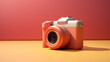 © Natallia - An unusual compact camera in a delicate peach fuzz color against a bright background of pink and yellow, with a contrasting shadow from the bright sunlight