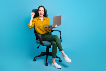 Wall Mural - Full length photo of positive lucky woman dressed yellow shirt winning game modern device empty space isolated blue color background