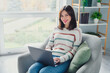 © deagreez - Portrait of lovely positive lady sit chair use wireless laptop coworking networking modern apartment inside
