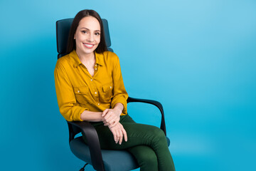 Poster - Photo of positive good mood woman dressed yellow shirt sitting armchair empty space isolated blue color background