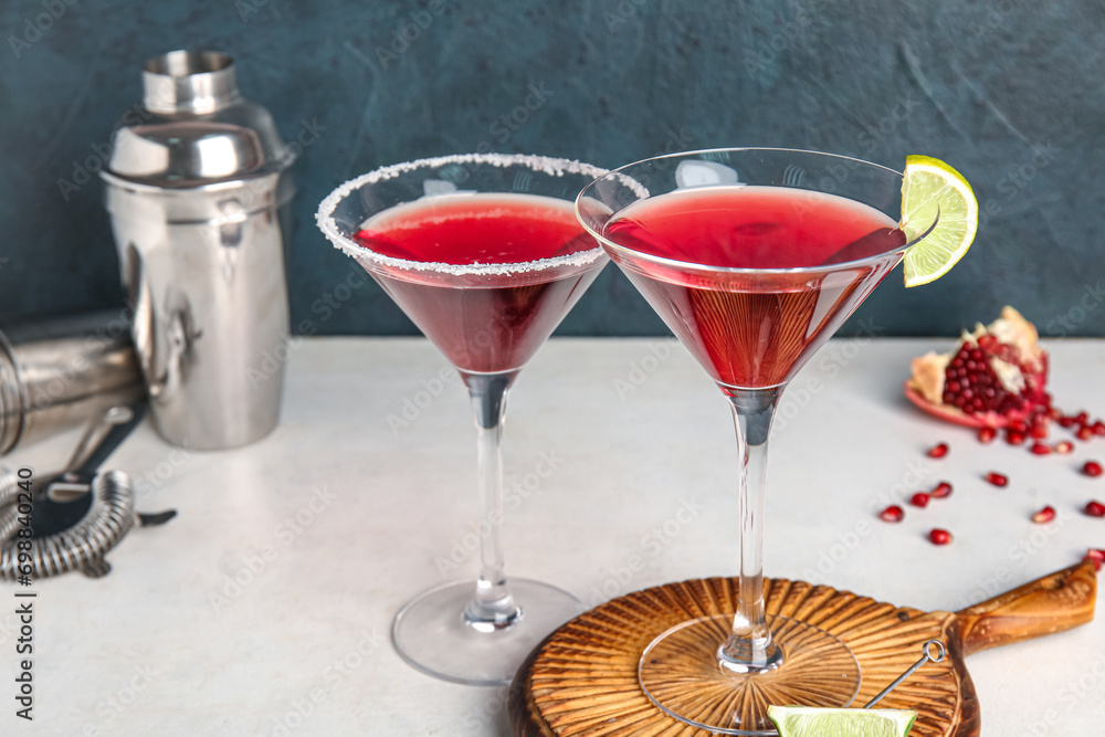 Glasses of Cosmopolitan cocktail with lime on white table