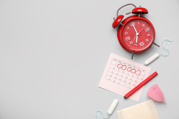 Wall Mural - Composition with menstrual calendar, feminine hygiene products and alarm clock on grey background