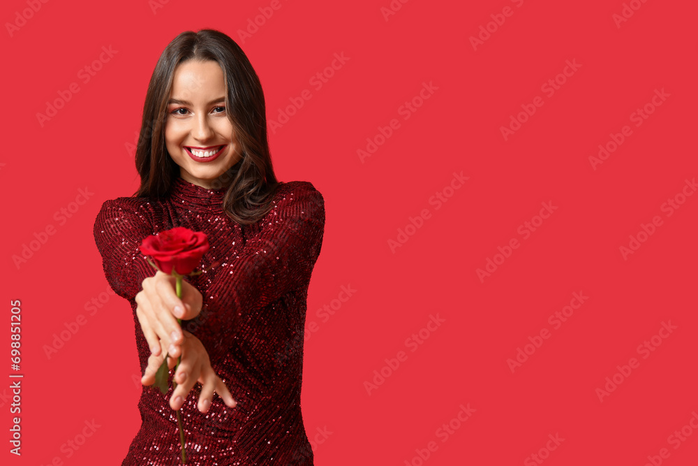 Beautiful young woman with red rose on color background. Valentine's Day celebration