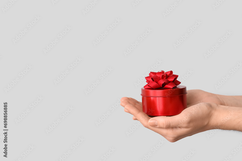 Female hands with gift boxes on grey background. Valentine's Day celebration