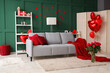 © Pixel-Shot - Interior of festive living room with grey sofa, bouquet of roses and heart-shaped balloons. Valentine's Day celebration
