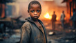 A poor little boy stands in a smoking dump on the outskirts of a slum. Poverty and hunger concept. Help hungry children