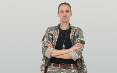 Ukrainian soldier wearing military uniform with flag and chevron depicting trident - Ukrainian national symbol flag