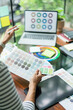 © snowing12 - Creative graphic designer holding color swatch and comparing color on laptop for designing project