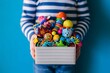 © boopul - A child holding a box filled with colorful toys
