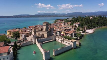 Wall Mural - The historical part of the city of Sirmione on Lake Garda in Italy, slow motion shot by drone. Scaliger Castle of the city of Sirmione 4K video on drone. Sirmione high altitude view.