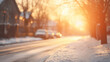 Sunset casting a golden glow on a snowy street in a residential neighborhood, with the warmth contrasting the winter chill.