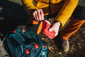 Open a first aid kit with medicines, a hiker on a hike uses a first aid kit, tourist equipment, survival in the forest.