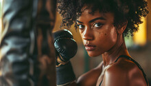 A Close-up Of A Beautiful Athletic Black Woman Boxing And Hitting A Punching Bag, Representing Female Empowerment During Black History Month,