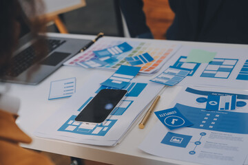 Close up ux developer and ui designer use augmented reality brainstorming about mobile app interface wireframe design on desk at modern office.Creative digital development agency