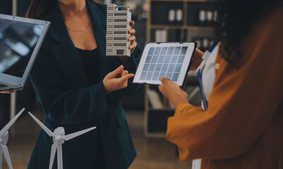 Wall Mural - Electrical engineer with businessman discussing new project installation solar cell panel on the roof of building. Alternative energy concept.