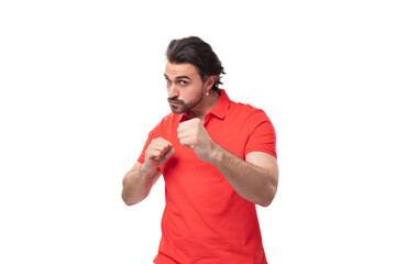 Wall Mural - young brunette man with a beard is dressed in a red t-shirt with a mockup on a white background with copy space. corporate clothing