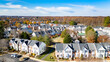 Drone Aerial Street and Rooftop View of Small Town Community Housing in Fall with Blue Sky's and Fall Tree Colors