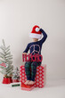 © Tamara Sales  - little boy on a white background posing for christmas photos colors red and green with a small christmas tree