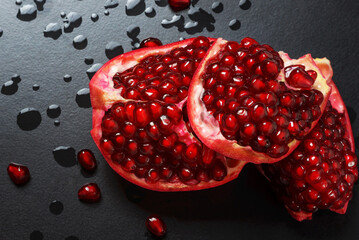 Wall Mural - Delicious beautiful red and burgundy pomegranate on a dark background.