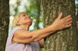 © yavdat - The woman s gentle hug to the tree exudes a sense of peace; a silent communion with the earth s enduring spirit.