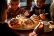Children at the table with Swedish semla buns with whipped cream
