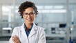 Portrait of a woman smiling in a medical lab coat, representing a healthcare professional