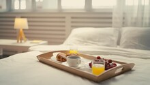 A tray with coffee, pastry and fruit standing on bed, breakfast in a cozy hotel